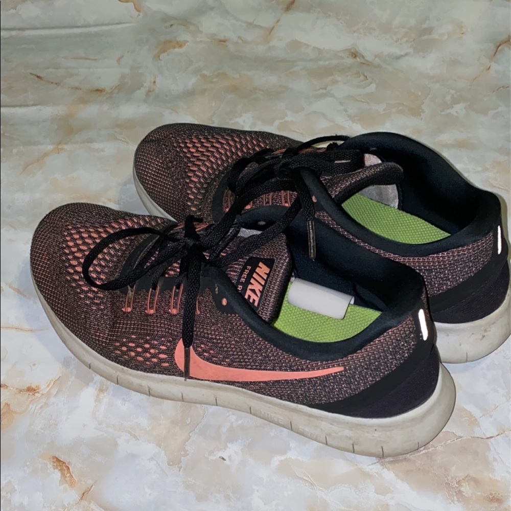 Black and pink women’s Nike tennis shoes